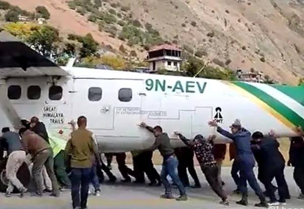 Passengers and airport staff push pதள்ளு...தள்ளு.. தள்ளு... டயர் பஞ்சராகி நின்ற விமானத்தை கைகளால் தள்ளிய ஊழியர்கள்: வைரலாகும் வீடியோlane off runway in Nepal after tyre burst; clip goes viral
