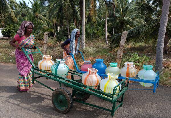 Villagers collect water on the dangerous journey on the road in trolleys for Cauvery drinking water   காவிரி குடிநீருக்காக கிராம மக்கள் ரோட்டில் ஆபத்தான பயணம் தள்ளுவண்டியில் தண்ணீர் சேகரிக்கின்றனர்